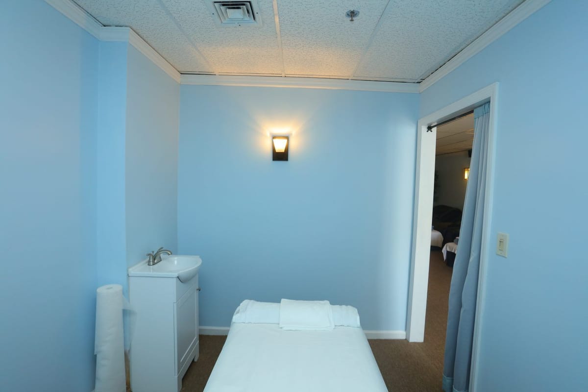 A serene blue massage treatment room at Paradise Massage